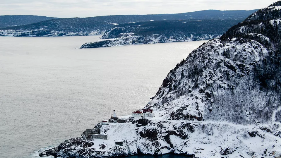 Rugged coast line covered in snow. Photo.