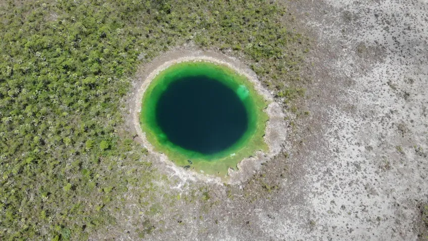 An aerial photograph of a hole with black water.